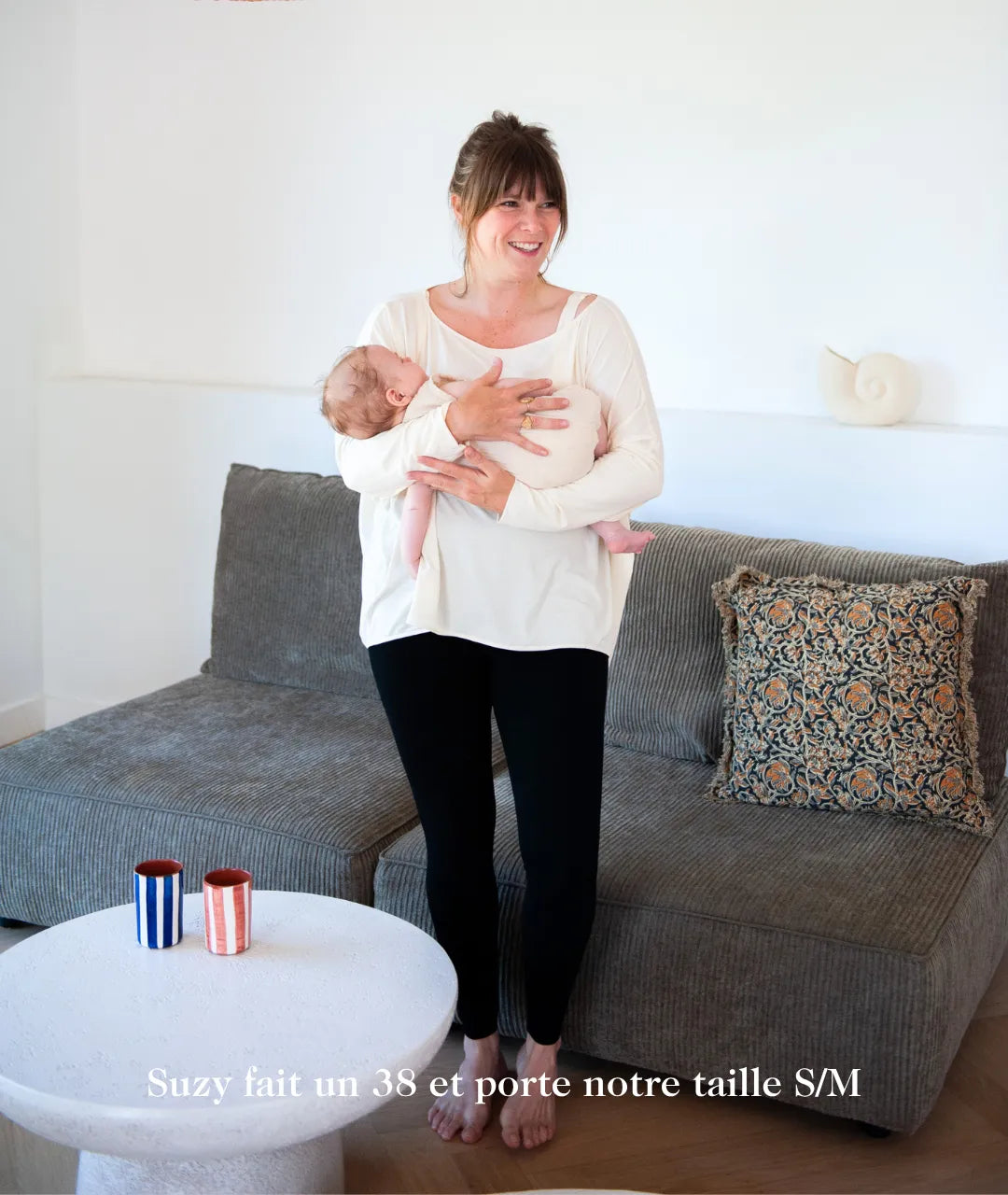 Jeune maman portant son legging de grossesse mama hangs avec son bébé dans les bras 